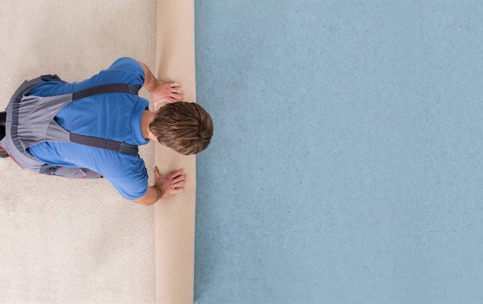 flooring contractor rolling out carpet