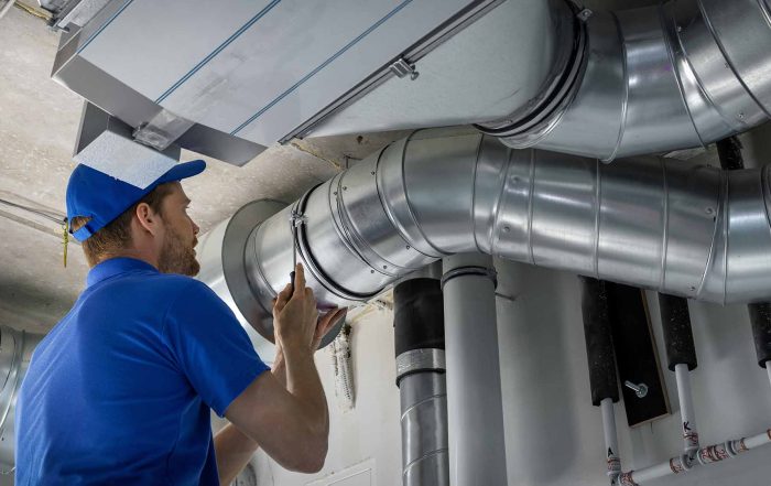 HVAC worker installing ducted pipe system